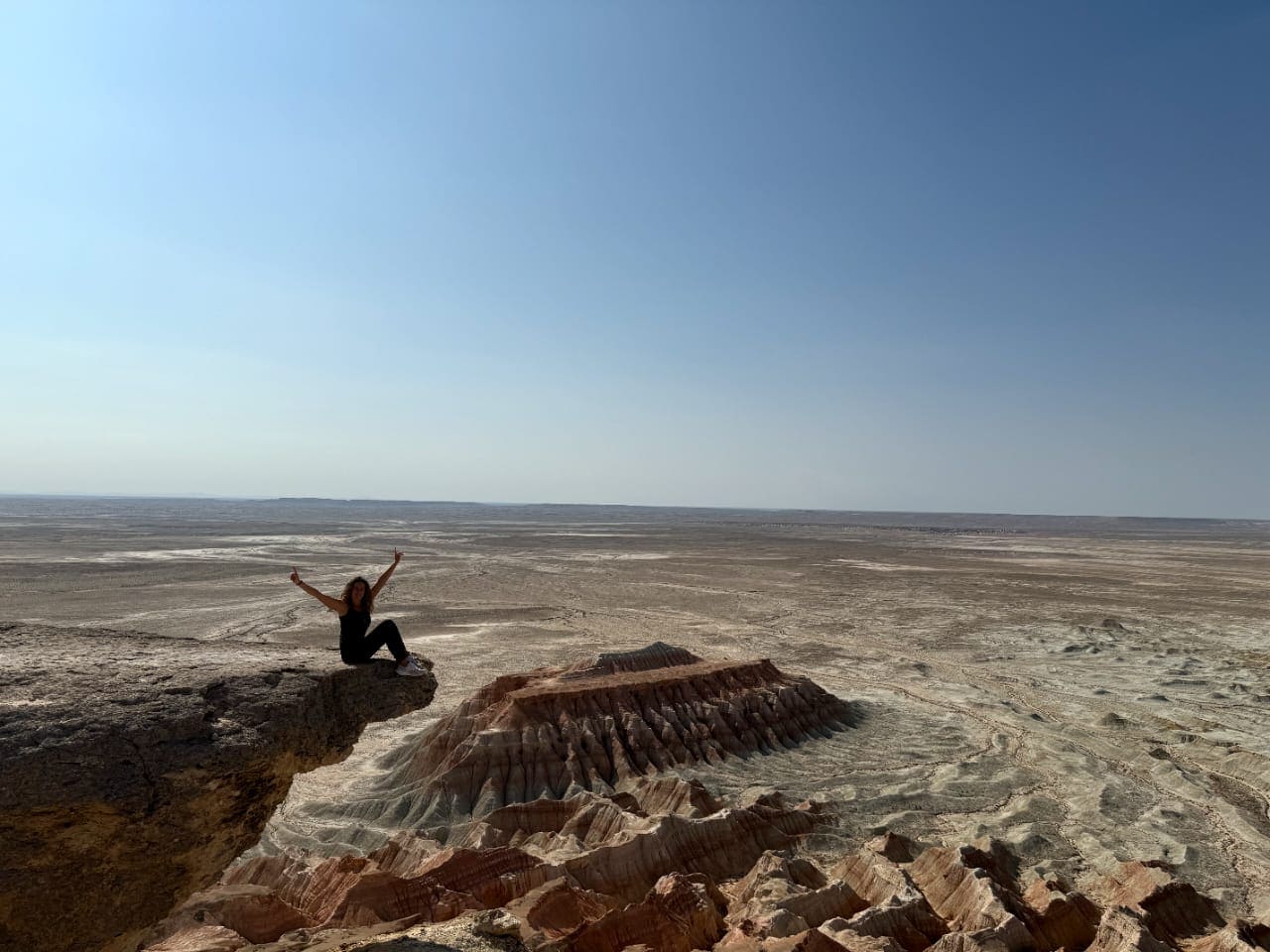 Tourist enjoying panoramic view of Yangykala Canyon colorful cliffs
