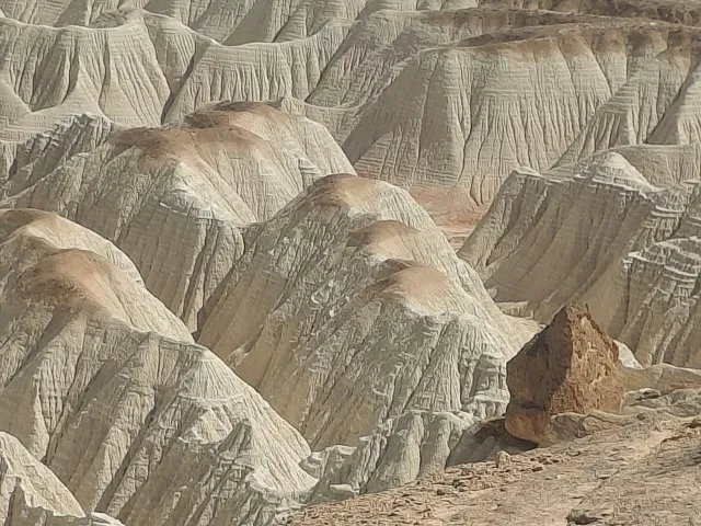Layered hills of the Moon Mountains in Turkmenistan with a distinctive undulating relief and sandy peaks.